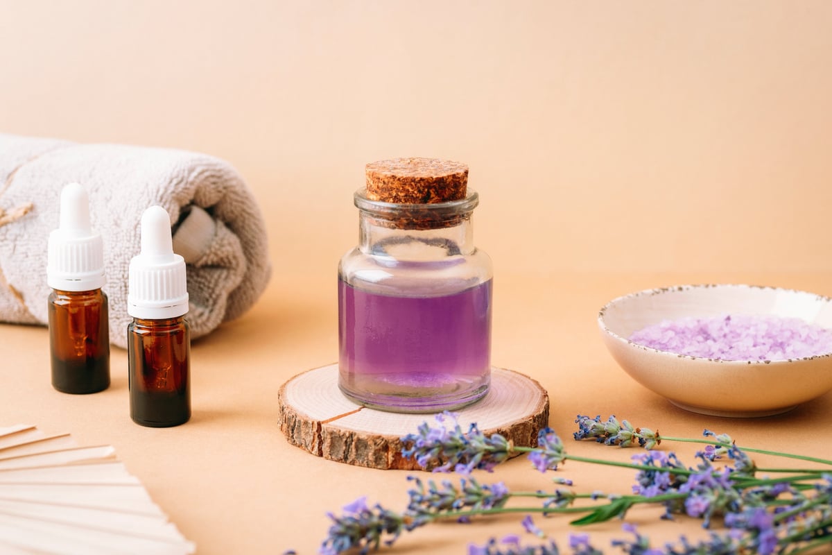 Lavender oil, bath salt, and a towel for spa treatment on a beige background